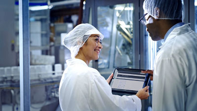 two scientists talking and showing content on tablet