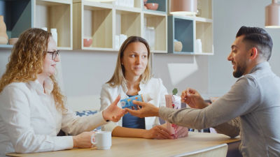colleagues sitting around table holding cartons