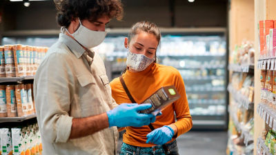 People in face masks reading on carton package