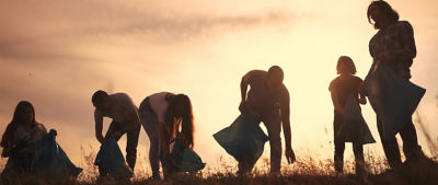 people collecting plastic in sunset