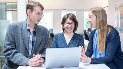 Experts talking in front of a laptop