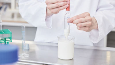 研究所でヨーグルトの検査を行う男性、テトラパックの食品専門家