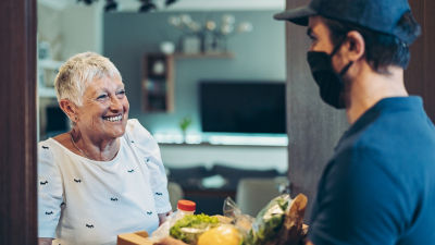 Man deliverying groceries to lady