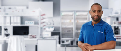 Hombre en camiseta de polo de pie en el laboratorio, mirando la cámara
