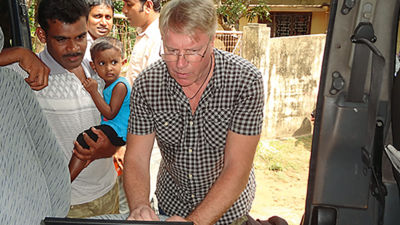 people gather around man with computer