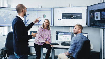 Personas en una reunión analizando datos en pantallas de computadoras