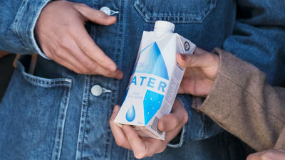 una persona sujeta un envase de cartón de agua