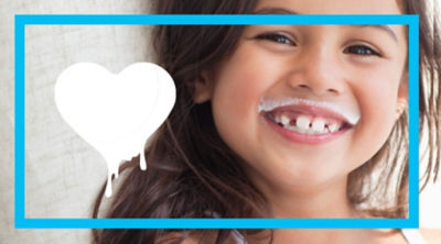 girls smiling with a yoghurt moustache 