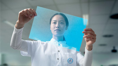 L’immagine mostra una donna in un’uniforme Tetra Pak bianca, che tiene in mano un foglio blu traslucido e lo esamina. Sembra concentrata, con il foglio tenuto sopra la testa, che indica un laboratorio o un ambiente tecnico.