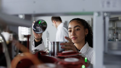 Une femme est concentrée sur le réglage d’un équipement technique.
