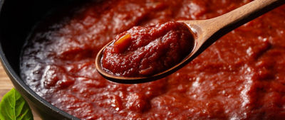 Puré de tomate y una cuchara de madera 