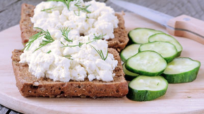 Tvarog cheese on bread, with sliced cucumber.