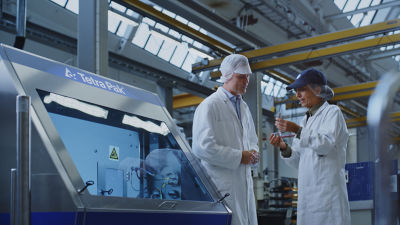 Two experts speaking next to homogenizer