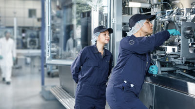 Dos trabajadores de fábrica reparando una máquina