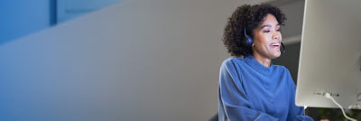 woman looking at laptop with headphones