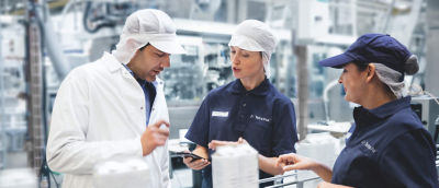 Three workers talking together in a lab