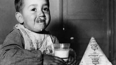 baby drinking a glass of milk
