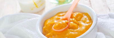 baby food in a white bowl with a spoon. 
