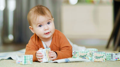 Baby on blanket with baby food in Tetra Recart carton package