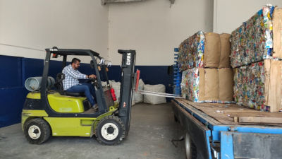 Luis Ferrari, manobrando um fardo de embalagem cartonada para reciclagem