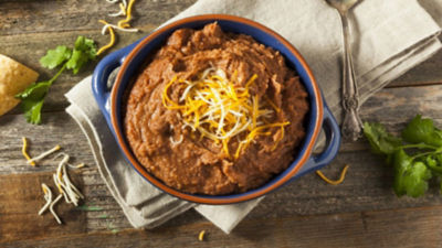 Refried beans in pot with cheese on top