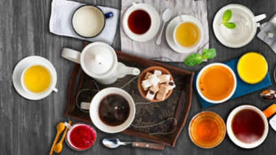 Beverages set on table including coffee milk tea and juice