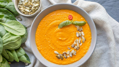 Pumpkin soup in bowl with pumpkin seeds on top