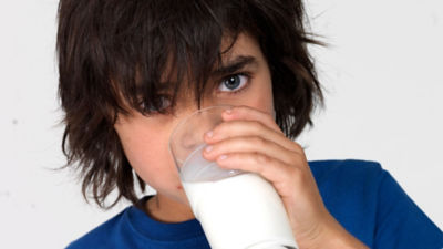 Boy with longer hair drinking milk