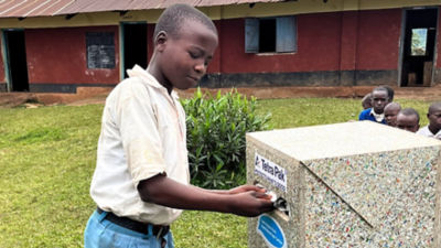 School boy putting Tetra Pak carton in recycling bin