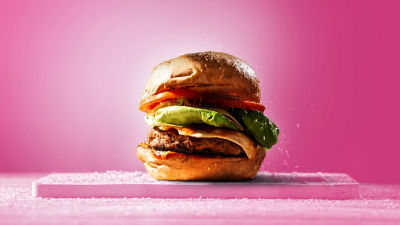 Una hamburguesa con fondo rosado