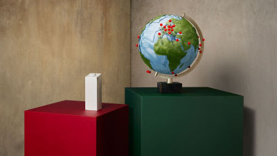 globe with red pins and a carton