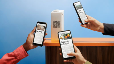 紙容器の QR コードをスキャンするスマートフォン
