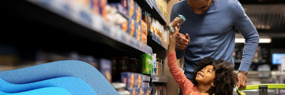 Kind und Vater wählen Kartonverpackung von Tetra Pak im Supermarkt aus