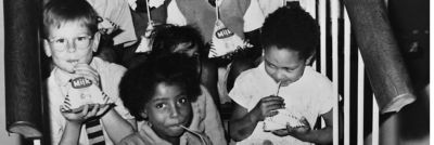 Children drinking milk from cartons with a straw