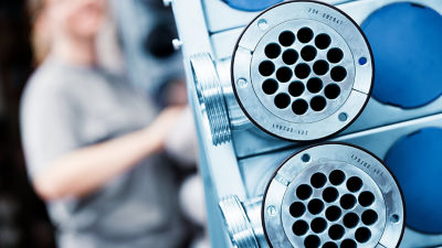Close-up image of a heat exchanger with a blurry person in the background