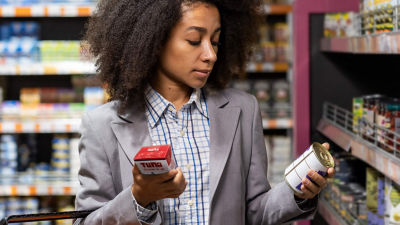 Woman evaluating alternatives, carton or can