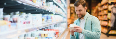Man in shop holding cottage cheese.