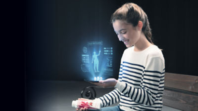 ネット接続された紙容器のホログラムを見る少女