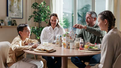 Family having breakfast, chilled cartons on the table