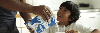 Father pouring milk for his son