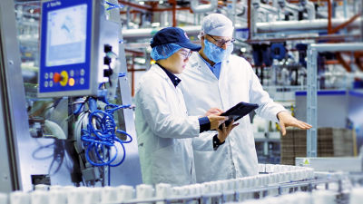 Operadores con una tableta en la línea de producción