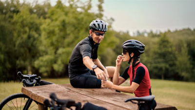people at a table outdoors with a bicycle