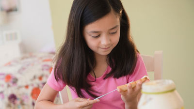 Girl spreading mayonnaise on bread