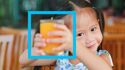 Niña sosteniendo un vaso de jugo de naranja