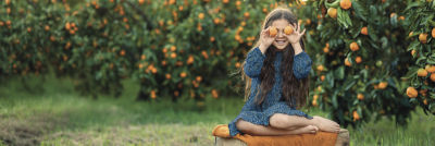 Girl with oranges over her eyes