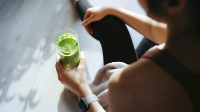 mujer sosteniendo un jugo después del entrenamiento