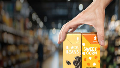 Hands holding Tetra Recart cartons, beans and sweet corn