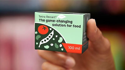 Hand holding Tetra Recart 100 mini carton package