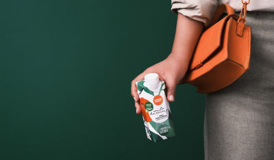 Women with orange handbag, holding Tetra Prisma Aseptic carton package