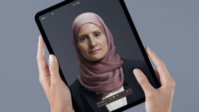 Hands holding an ipad with woman on screen